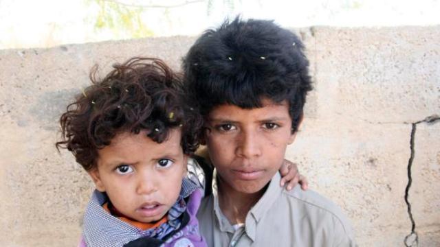Mohammed Saleh Qayed Taeiman poses for a photo with his younger brother outside their family's house in Marib province