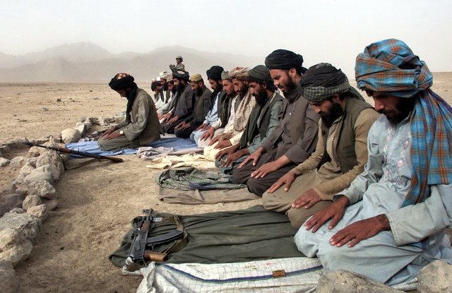 Taliban fighters pray in the outskirts of the city of Kandahar, Afghanistan in this November 3, 2001 file photo. Almost five years after thousands of Taliban fighters fled Afghanistan to escape a U.S.-led invasion, Pakistan is still unable to shake off suspicions that it is allowing them to operate from its soil. REUTERS/Mian Khursheed/Files (PAKISTAN)