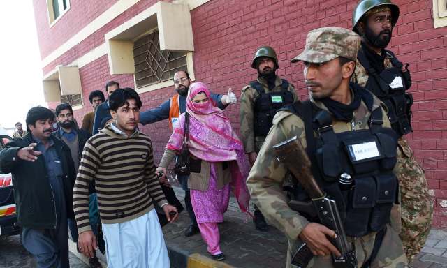 Pakistani army soldiers rescue people from Bacha Khan university following an attack by militants in Charsadda, about 50 kilometres from Peshawar, on January 20, 2016. At least 21 people died in an armed assault on a university in Pakistan on January 20, where witnesses reported two large explosions as security forces moved in under dense fog to halt the bloodshed. AFP PHOTO / A MAJEED