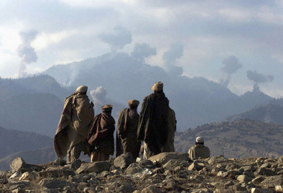 Original caption: Anti-Taliban Afghan fighters watch several explosions from U.S. bombings in the Tora Bora mountains in Afghanistan, December 16, 2001. Hundreds of al Qaeda fighters have battled to the death in a last stand in eastern Afghanistan, but their leader Osama bin Laden eluded the U.S. dragnet, Afghan commanders said on Sunday. REUTERS/Erik de Castro